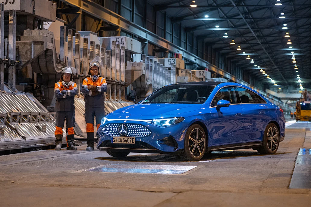 a blue car with a couple of men standing next to it