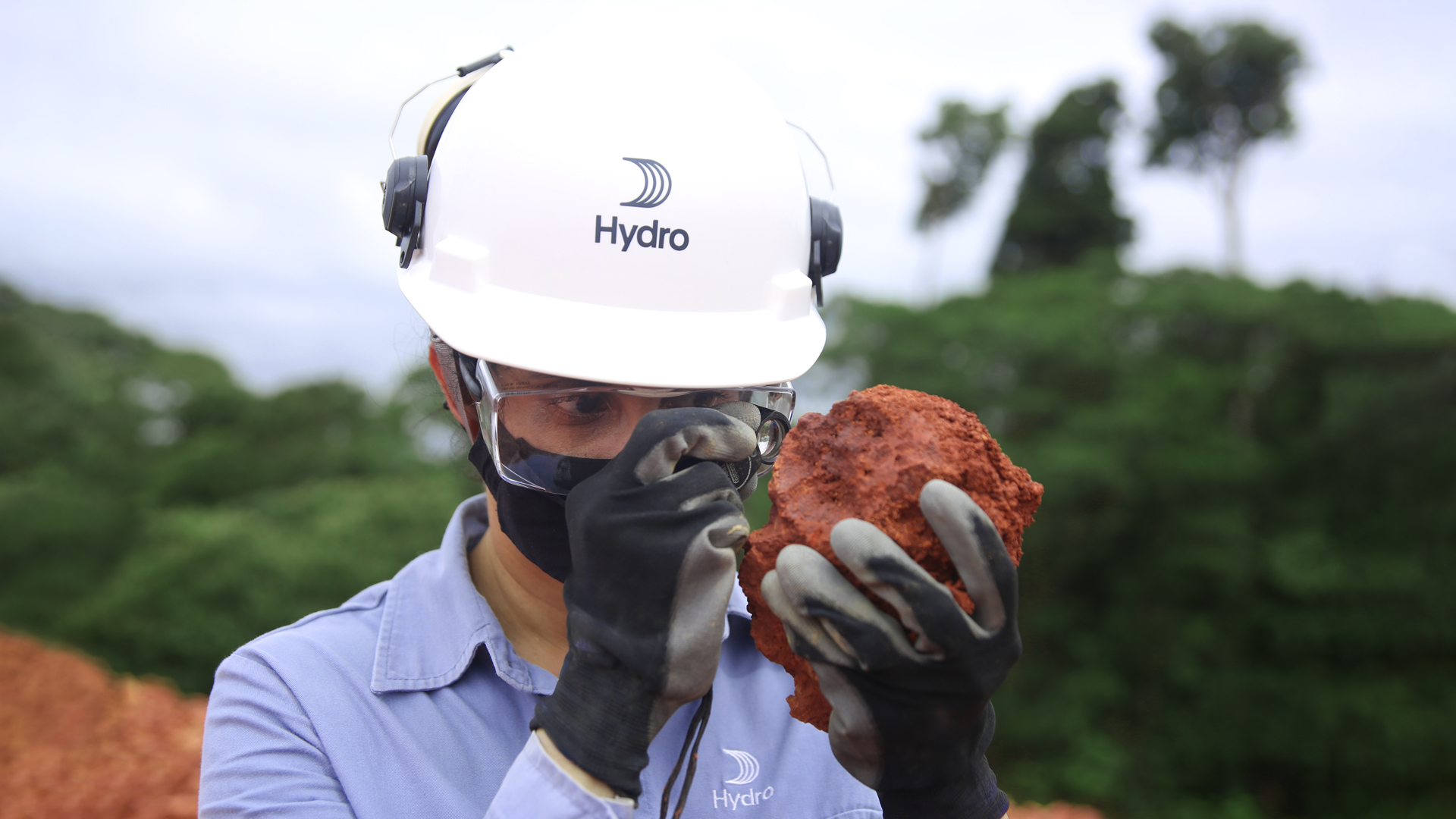 a person wearing a helmet and goggles holding a rock