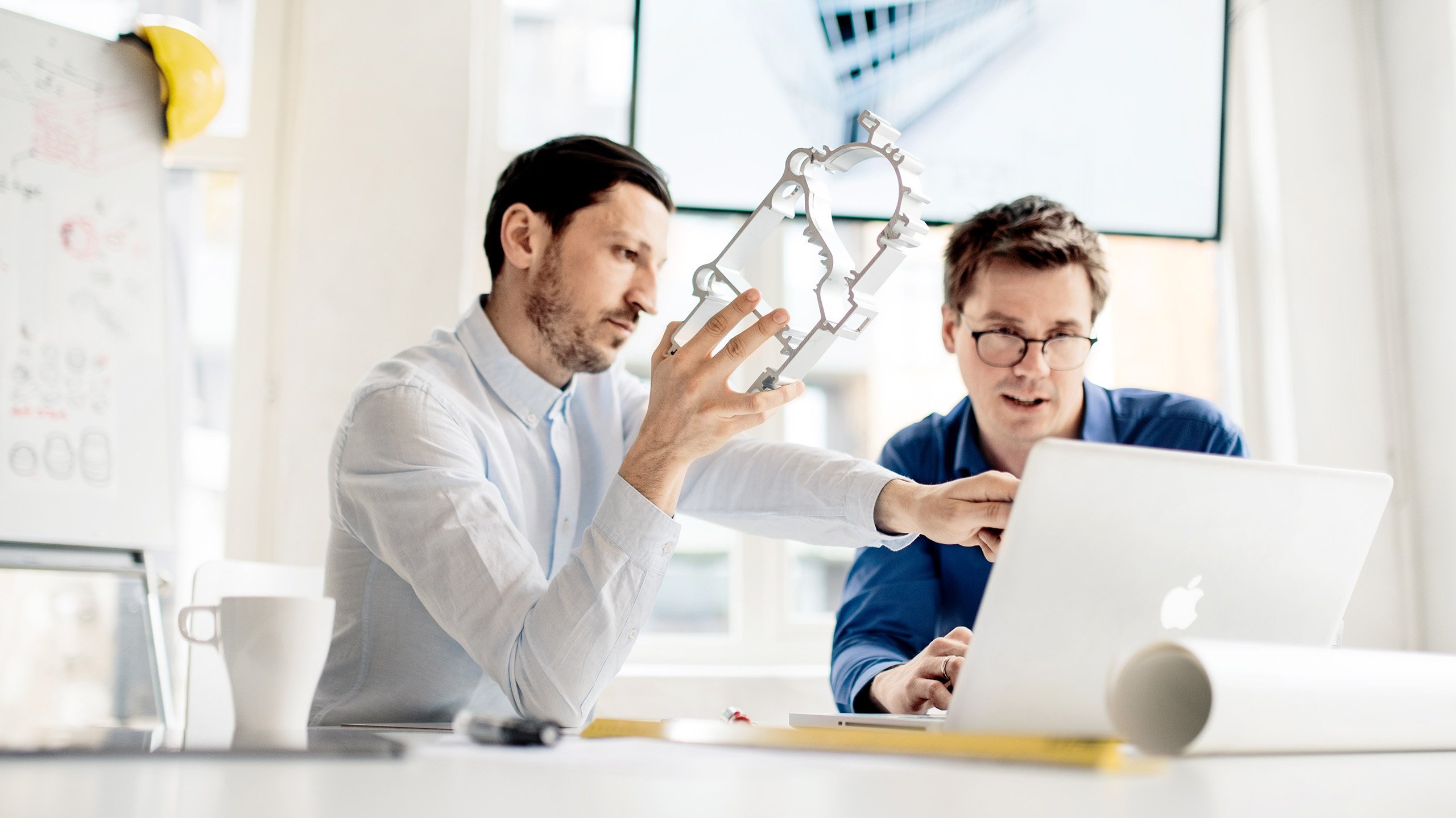 a man showing a man something on the computer