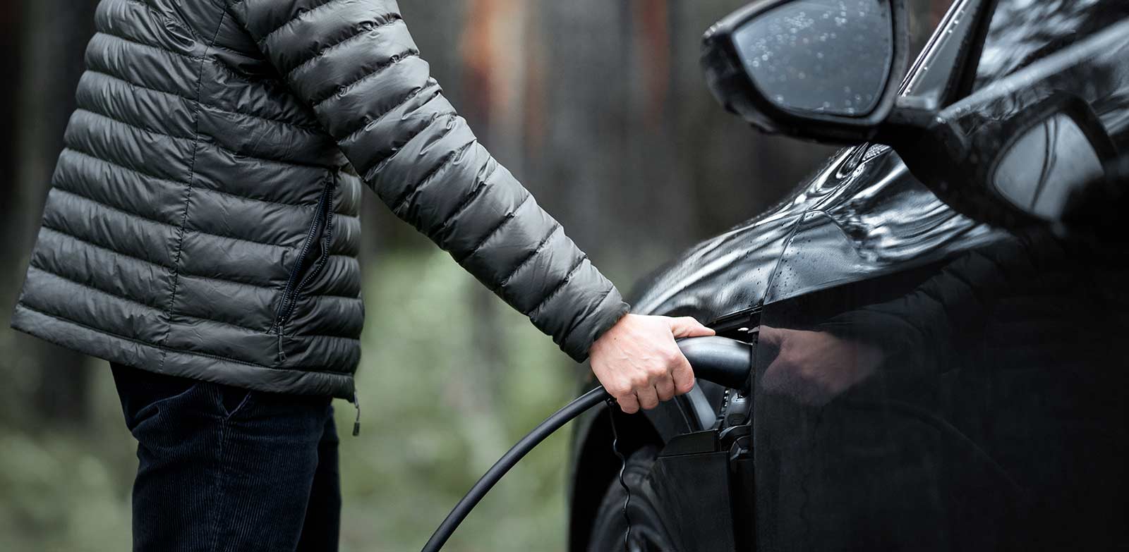 Man charging electric vehicle 