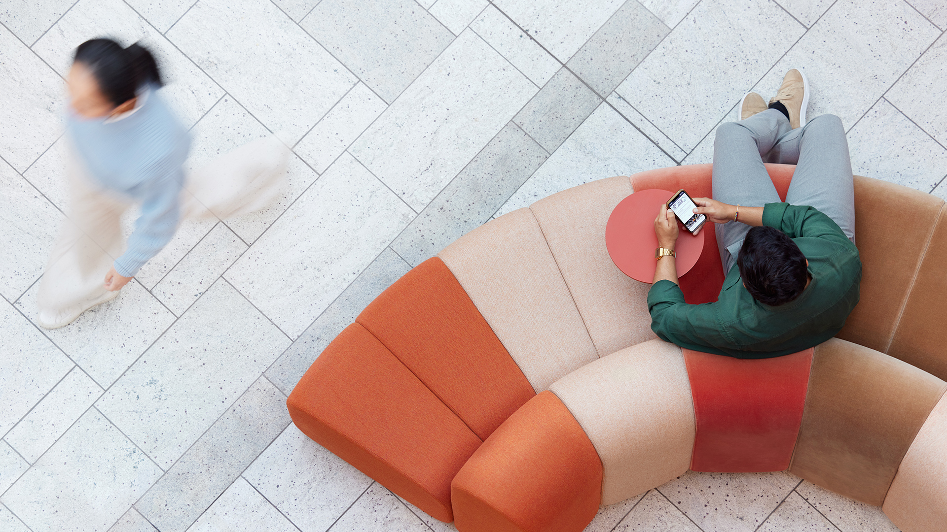 a man and woman sitting on orange couches