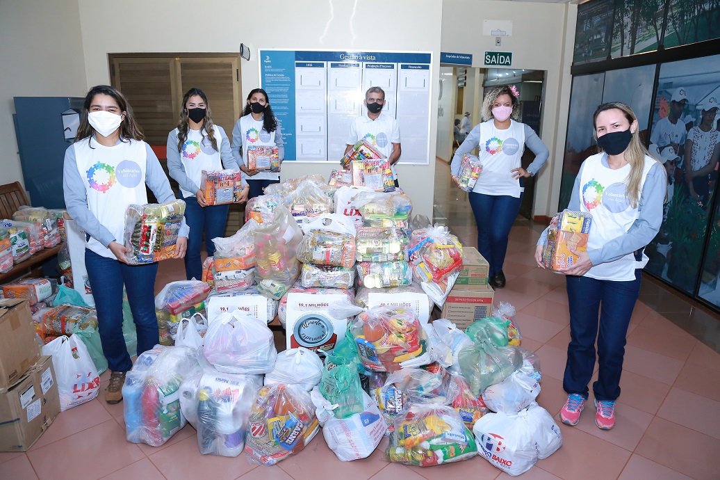 a group of women standing next to a pile of plastic bags