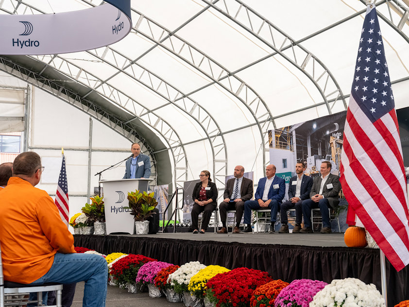a group of people sitting on a stage with flags