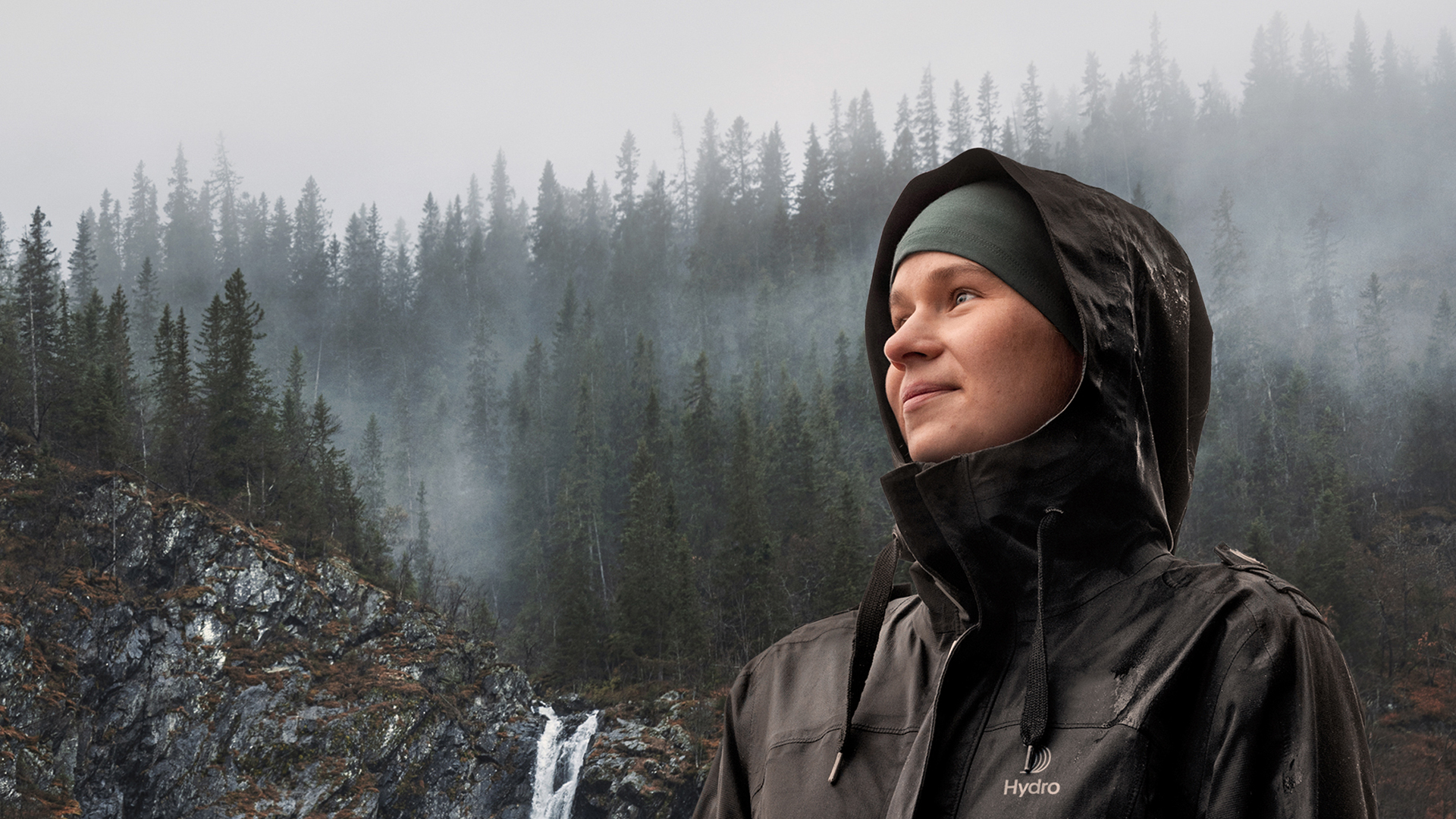 a person wearing a hoodie and standing on a snowy hill