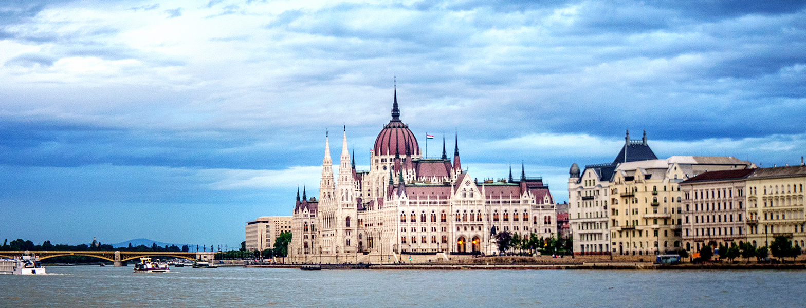 a large building with towers by a body of water